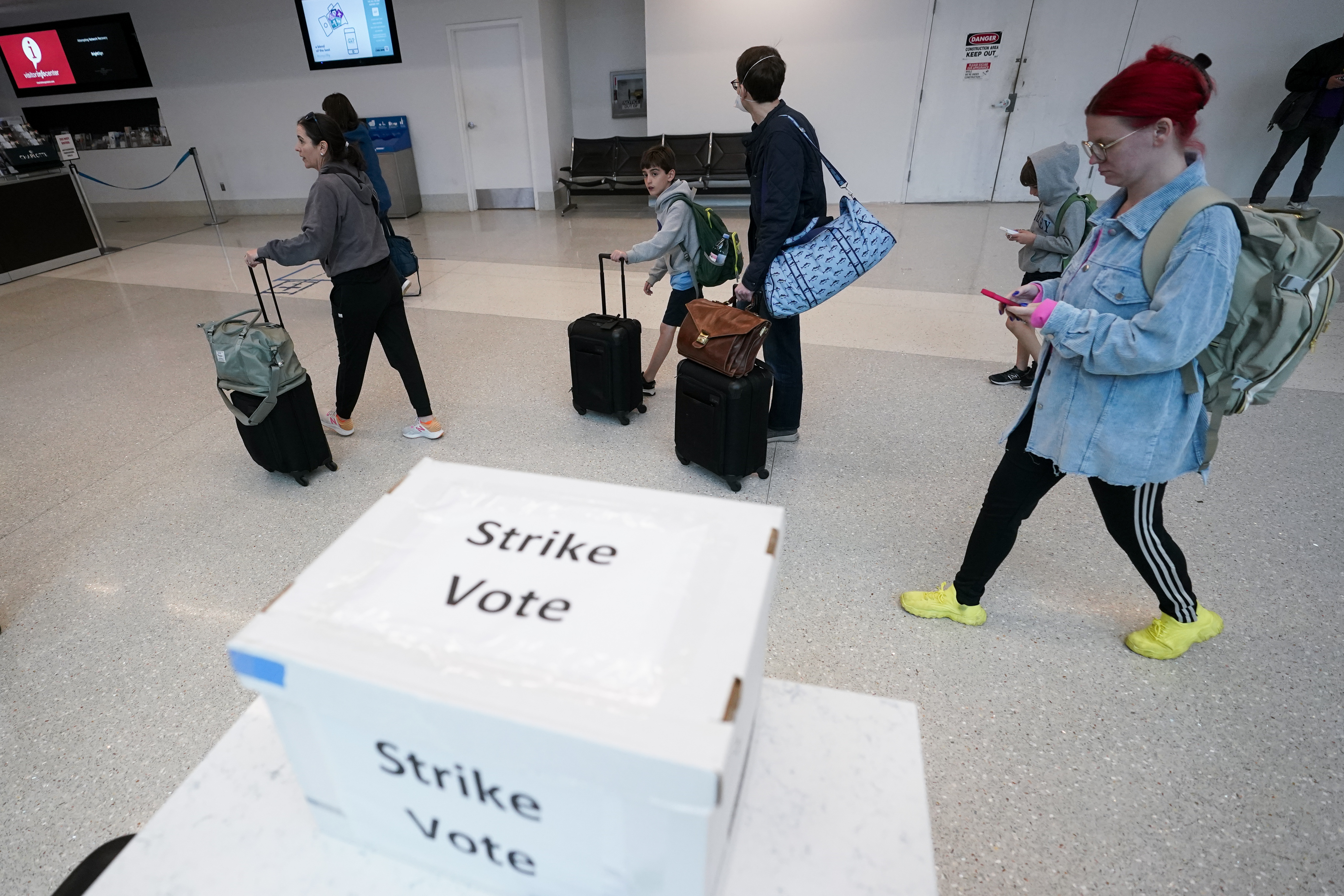 Passengers walks past a union ballot drop box at Charlotte Douglas International Airport, Friday, Nov. 22, 2024, in Charlotte, N.C. (AP Photo/Erik Verduzco)